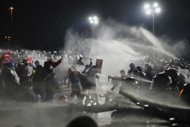 Agentes de policía antimotines chocan con manifestantes durante una protesta tras el arresto y envío a prisión del alcalde de Estambul, Ekrem Imamoglu, en Estambul, Turquía, el domingo 23 de marzo de 2025. (AP Foto/Francisco Seco)