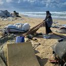 Una mujer jala una alfombra después de que lluvias nocturnas inundaran un campamento de tiendas de campaña junto a la playa, el domingo 28 de diciembre de 2025, en Jan Yunis, en el sur de la Franja de Gaza. (AP Foto/Mohammad Jahjouh)