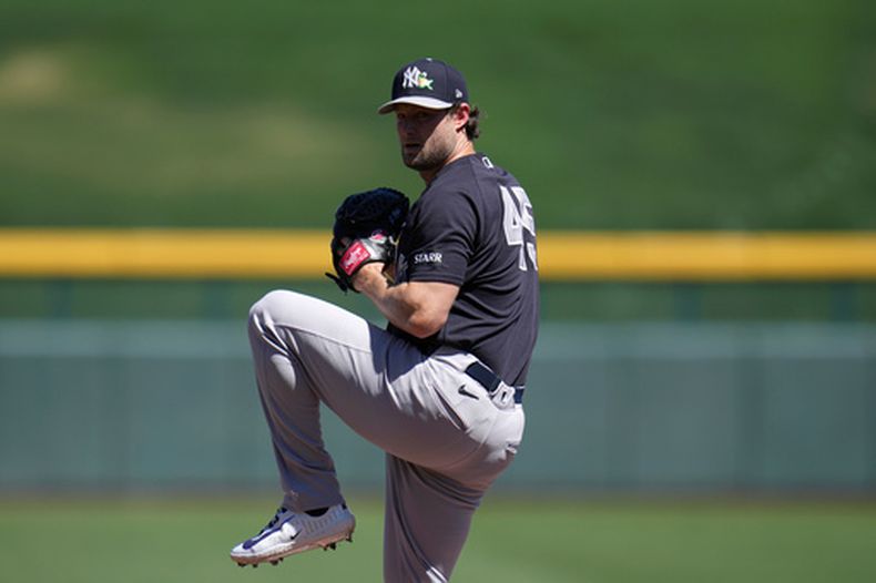 El lanzador abridor de los Yankee de Nueva York, Gerrit Cole, calienta durante la primera entrada de un partido de béisbol de entrenamiento de primavera contra los Cachorros de Chicago, el martes 24 de marzo de 2026, en Mesa, Arizona. (AP Foto/Ross D. Franklin)
