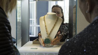 Una empleada de Christies exhibe el collar de diamantes y esmeraldas Great Mogul creador por Harry Winston, con un precio estimado entre 450.000 y 640.000 francos suizos, en una vitrina, durante la vista previa de El mundo de Heidi Horten, la colección de 700 joyas de la difunta multimillonaria austriaca Heidi Horten, en la casa de subastas Christies en Ginebra, Suiza, el lunes 8 de mayo de 2023. (Salvatore Di Nolfi/Keystone vía AP)