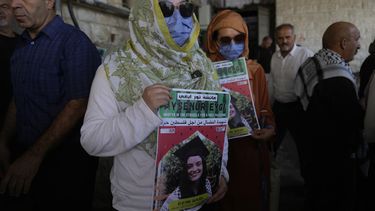 Dos compañeras activistas de Aysenur Ezgi Eygi, de 26 años, que según un testigo murió por disparos de soldados israelíes durante una protesta contra los asentamientos en Cisjordania, portan carteles con su nombre durante su funeral en la ciudad cisjordana de Nablus, el 9 de septiembre de 2024. (AP Foto/Nasser Nasser)