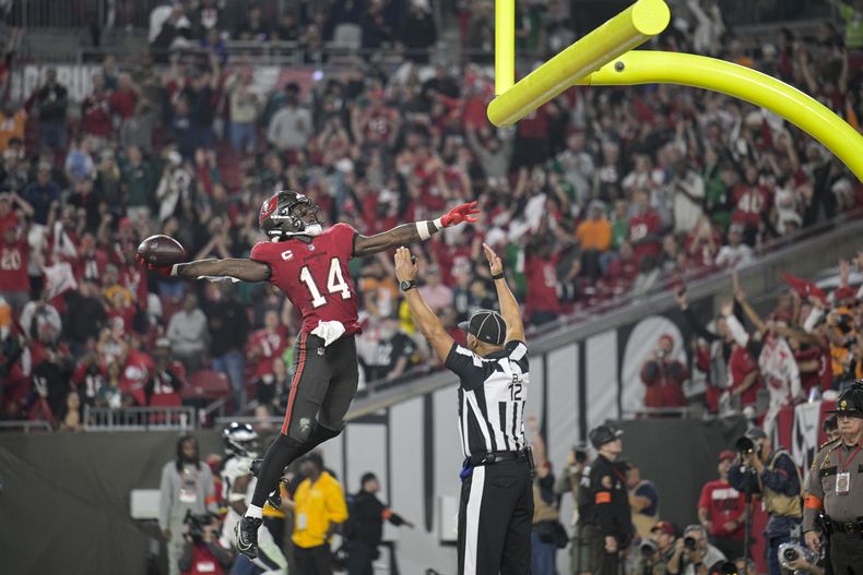 El wide receiver Chris Godwin (14), de los Buccaneers de Tampa bay, celebra después de una recepción de touchdown, mientras el árbitro Greg Steed (12) marca la anotación, durante la segunda mitad del juego de comodines de la NFL en contra de los Eagles de Filadelfia, el lunes 15 de enero de 2024, en Tampa, Florida. (AP Foto/Phelan M. Ebenhack)