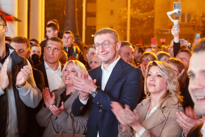 Hristijan Mickoski, al centro, líder del partido conservador VMRO-DPMNE celebra frente a la sede del partido después de anunciar una gran victoria en las elecciones locales, el domingo 2 de noviembre de 2025, en Skopie, Macedonia del Norte. (AP Foto/Boris Grdanoski)
