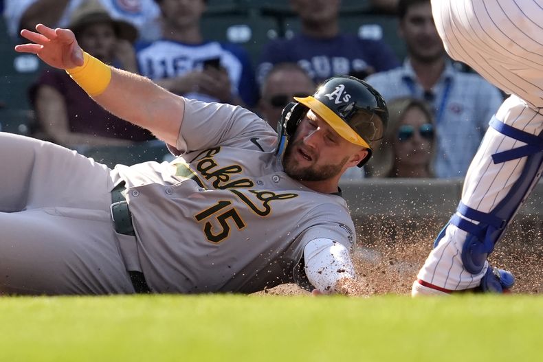 Seth Brown (izquierda) de los Atléticos de Oakland anota una carrera ante los Cachorros de Chicago, el miércoles 18 de septiembre de 2024, en Chicago. (AP Foto/Nam Y. Huh)