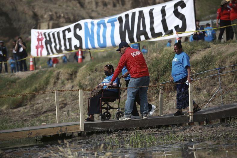 Personas que viven en Estados Unidos se reúnen con parientes y amigos que radican en México durante el 10mo evento anual Abrazos, no muros, en la franja del Río Bravo, en Ciudad Juárez, México, el sábado 6 de mayo de 2023. (AP Foto/Christian Chávez)