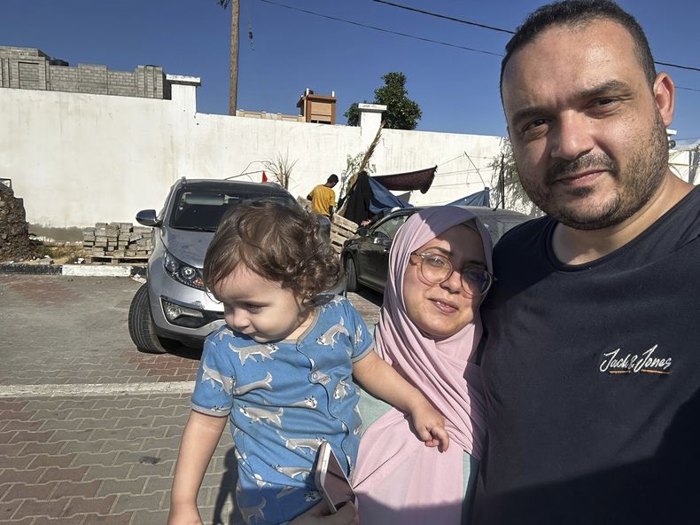 Esta fotografía proporcionada por Hosein Owda y fechada el domingo 15 de octubre de 2023 lo muestra junto con su esposa, Wafa, y su hijo Zein, de un año, en el campamento de refugiados de Jan Yunis. (Hosein Owda vía AP)