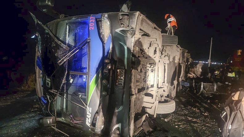 En esta fotografía proporcionada por la Policía de Caminos de Perú, los rescatistas atienden un autobús que chocó con un tren de carga en La Oroya, Perú, el domingo 26 de mayo de 2024. (Policía de Caminos de Perú, vía AP)
