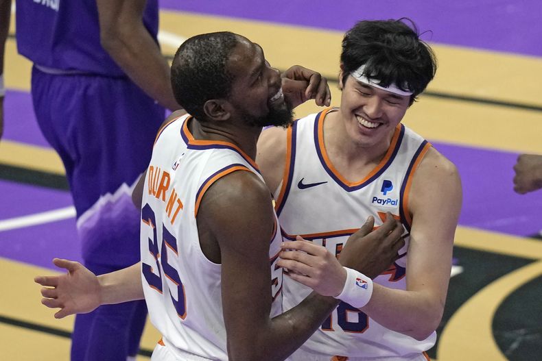 Kevin Durant, alero de los Suns de Phoenix, festeja con Yuta Watanabe, tras la victoria sobre el Jazz de Utah, el viernes 17 de noviembre de 2023 (AP Foto/Rick Bowmer)