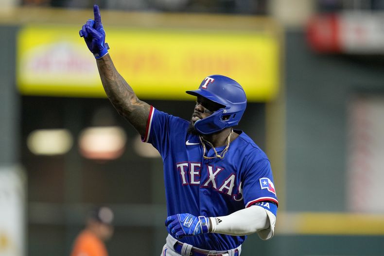 Adolis García de los Rangers de Texas reacciona luego de conectar grand slam en la novena entrada del 6to juego de la Serie de Campeonato de la Liga Americana ante los Astros de Houston, en Houston, el domingo 22 de octubre de 2023. (AP Foto/Godofredo A. Vásquez)