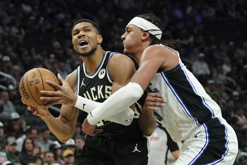 El griego Giannis Antetokounmpo, de los Bucks de Milwaukee, recibe una falta del italiano Paolo Banchero, del Magic de Orlando, el miércoles 15 de enero de 2025 (AP Foto/Aaron Gash)