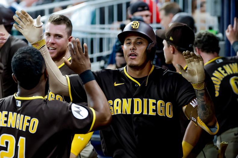El dominicano Manny Machado, de los Padres de San Diego, es felicitado en la cueva luego de disparar un jonrón en el duelo ante los Bravos de Atlanta, el martes 21 de julio de 2026 (AP Foto/Erik S. Lesser)