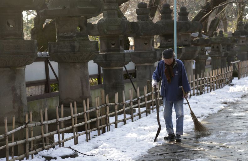 Un trabajador se retira despu&eacute;s de quitar la nieve de un patio en un templo en Tokio, el domingo 16 de febrero de 2014. (AP Foto/Shizuo Kambayashi)