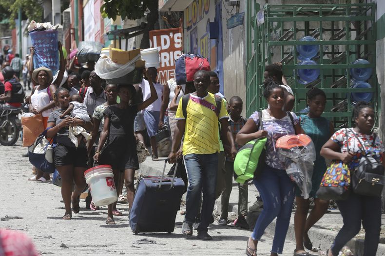 ARCHIVO - Residentes abandonan sus hogares en su huida de los enfrentamientos entre pandillas armadas en el distrito Carrefour-Feuilles de Puerto Príncipe, Haití, el 15 de agosto de 2023. (AP Foto/Odelyn Joseph, archivo)