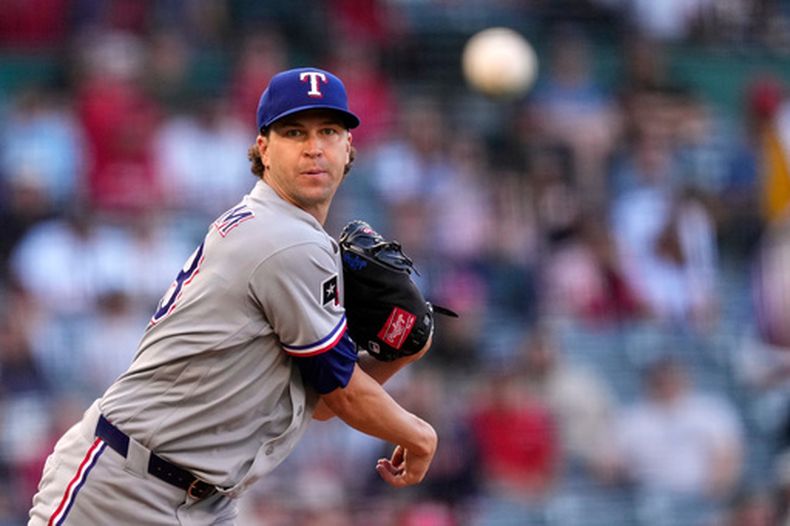 ARCHIVO - Jacob Degrom, de los Rangers de Texas, lanza a primera en un intento por atrapar fuera de base a Mike Trout, de los Angelinos de Los Ángeles, durante la primera entrada del juego de béisbol de Grandes Ligas, el viernes 22 de mayo de 2026, en Anaheim, California. (AP Foto/Mark J. Terrill, Archivo)