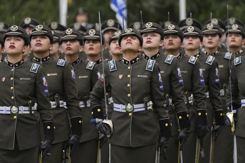 Agentes de policía guardan un minuto de silencio por las víctimas de la violencia en una ceremonia de entrega de equipamiento a la policía, en la escuela policía General Alberto Enríquez Gallo en Quito, Ecuador, el lunes 22 de enero de 2024. (AP Foto/Dolores Ochoa)