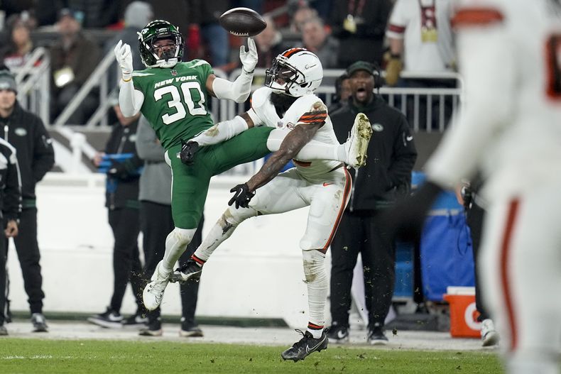 El wide receiver Elijah Moore, de los Browns de Cleveland, le quita una posible intercepción de las manos al cornerback Michael Carter II y después atraparía el balón, durante la primera mitad del partido de la NFL, el jueves 28 de diciembre de la NBA, en Cleveland. (AP Foto/Sue Ogrocki)
