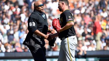 El umpire del plato Laz Diaz le da la mano al abridor de los Piratas de Pittsburgh Kirby Yates tras salir en la segunda entrada ante los Tigres de Detroit el sábado 26 de septiembre del 2026. (AP Foto/Jose Juarez)