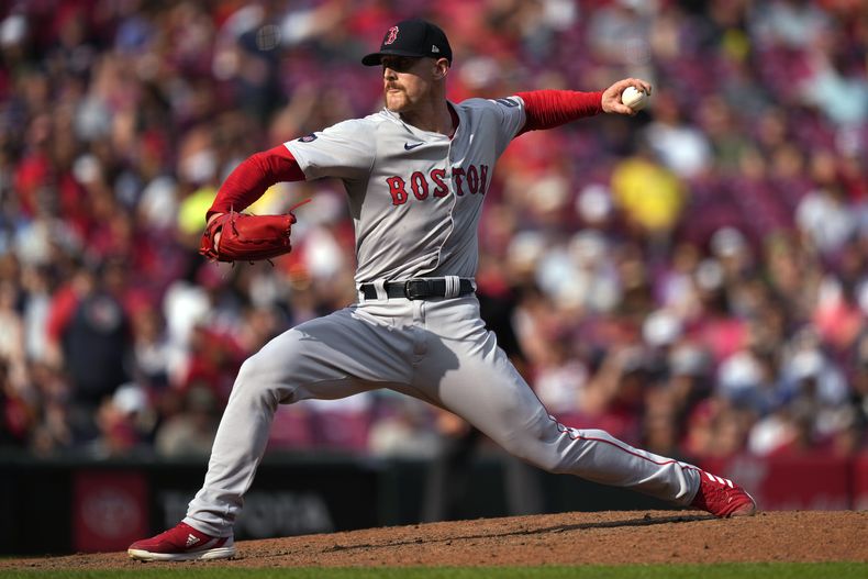 El lanzador de los Medias Rojas de Boston, Cam Booser, lanza a un bateador de los Rojos de Cincinnati durante la séptima entrada el sábado 22 de junio de 2024, en Cincinnati. (AP Foto/Carolyn Kaster)