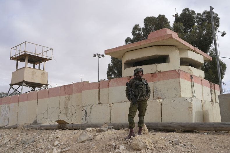 ARCHIVO - Un soldado istaelí contempla a manufestantes que cierran el paso a ayuda humanitaria que se dirige a Gaza en el cruce fronterizo de Nizaba entre Egipto y el sur de Israel, 2 de febrero de 2024. (AP Foto/Tsafrir Abayov, File)