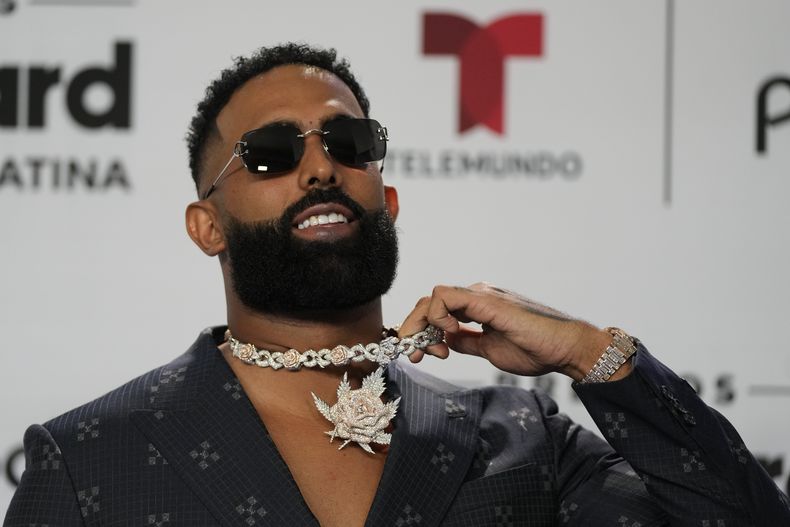 ARCHIVO - Eladio Carrión muestra su collar al posar para retratos en la alfombra azul de los Premios Billboard de la Música Latina en Coral Gables, Florida, el 5 de octubre de 2023. Carrión lanzó su álbum Sol María el 19 de enero de 2024. (Foto AP/Rebecca Blackwell, archivo)