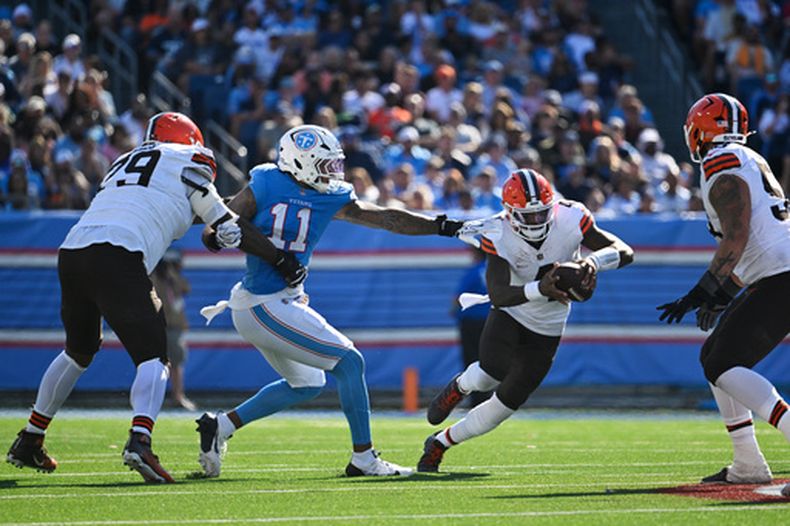 El quarterback de los Browns de Cleveland Deshaun Watson evita el defensive end de los Titans de Tennessee Jermaine Johnson II en el encuentro del domingo 25 de octubre del 2026. (AP Foto/John Amis)
