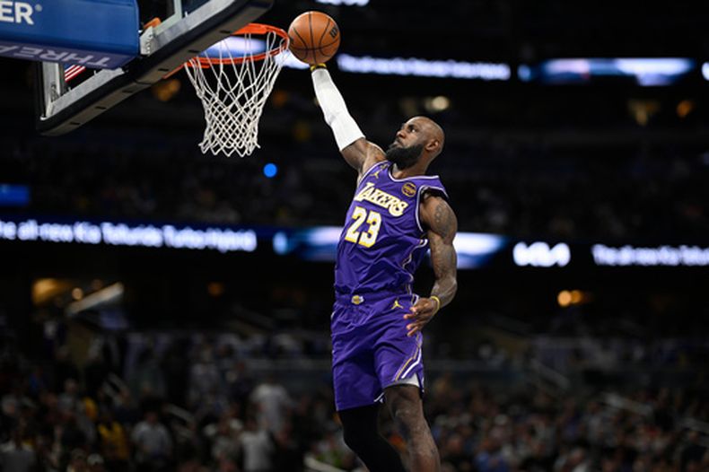 El alero de los Lakers de Los Ángeles, LeBron James (23), anota en una volcada en contraataque durante la primera mitad de un juego de baloncesto de la NBA contra el Magic de Orlando, el sábado 21 de marzo de 2026, en Orlando, Florida. (Foto AP/Phelan M. Ebenhack)