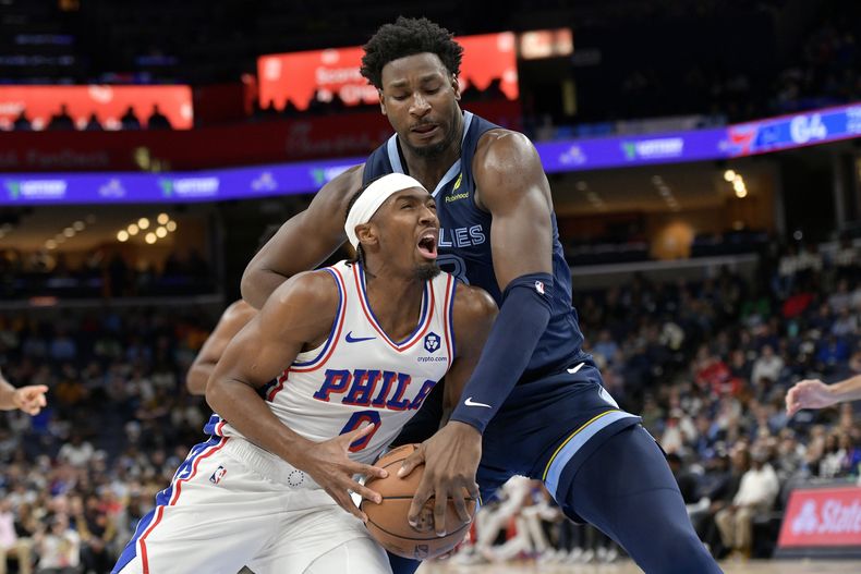 Tyrese Maxey (0), de los 76ers de Filadelfia, intenta avanzar ante la presión defensiva de Jaren Jackson Jr., de los Grizzlies de Memphis, en la segunda mitad del partido de baloncesto de la NBA, el miércoles 20 de noviembre de 2024, en Memphis, Tennessee. (AP Foto/Brandon Dill)