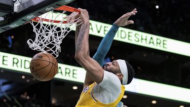 Anthony Davis, de los Lakers de Los Ángeles, clava el balón, mientras recibe una falta de Miles Bridges, de los Hornets de Charlotte, durante la segunda mitad del juego de baloncesto de la NBA, el lunes 5 de febrero de 2024, en Charlotte, Carolina del Norte. (AP Foto/Jacob Kupferman)