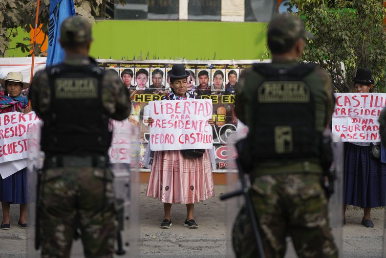 Seguidores del expresidente peruano Pedro Castillo, que está en prisión preventiva, lanzan proclamas fuera de la sede policial en la que se celebra el juicio en su contra por rebelión y otros delitos, a las afueras de Lima, Perú, el jueves 13 de marzo de 2025. (AP Foto/Martín Mejía)