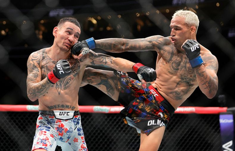 El brasileño Charles Oliveira (derecha) lanza un golpe a Max Holloway, en la función UFC 326 de artes marciales mixtas, el sábado 7 de marzo de 2026 (Steve Marcus/Las Vegas Sun via AP)/Las Vegas Sun via AP)