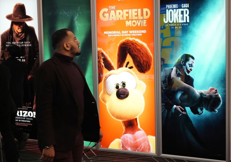 Un asistente pasa junto anuncios de próximas películas, incluidas The Garfield Movie y Joker: Folie a Deux, el día inaugural de CinemaCon 2024 en el Caesars Palace, el lunes 8 de abril de 2024, en Las Vegas. La convención de cuatro días de la Asociación Nacional de Propietarios de Cines se extenderá hasta el jueves. (Foto AP/Chris Pizzello)
