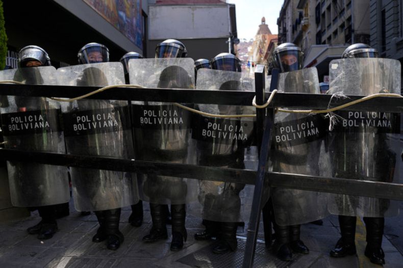 Agentes de policía montan guardia tras una valla durante las protestas antigubernamentales cerca del palacio de gobierno en La Paz, Bolivia, el lunes 1 de junio de 2026. (Foto AP/Juan Karita)