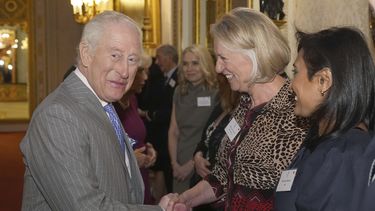 El rey Carlos III de Gran Bretaña saluda a una invitada durante una recepción en el Palacio de Buckingham, Londres, para invitados de una amplia gama de organizaciones de medios de todo el país, el miércoles 26 de marzo de 2025. (Aaron Chown, Pool via AP)