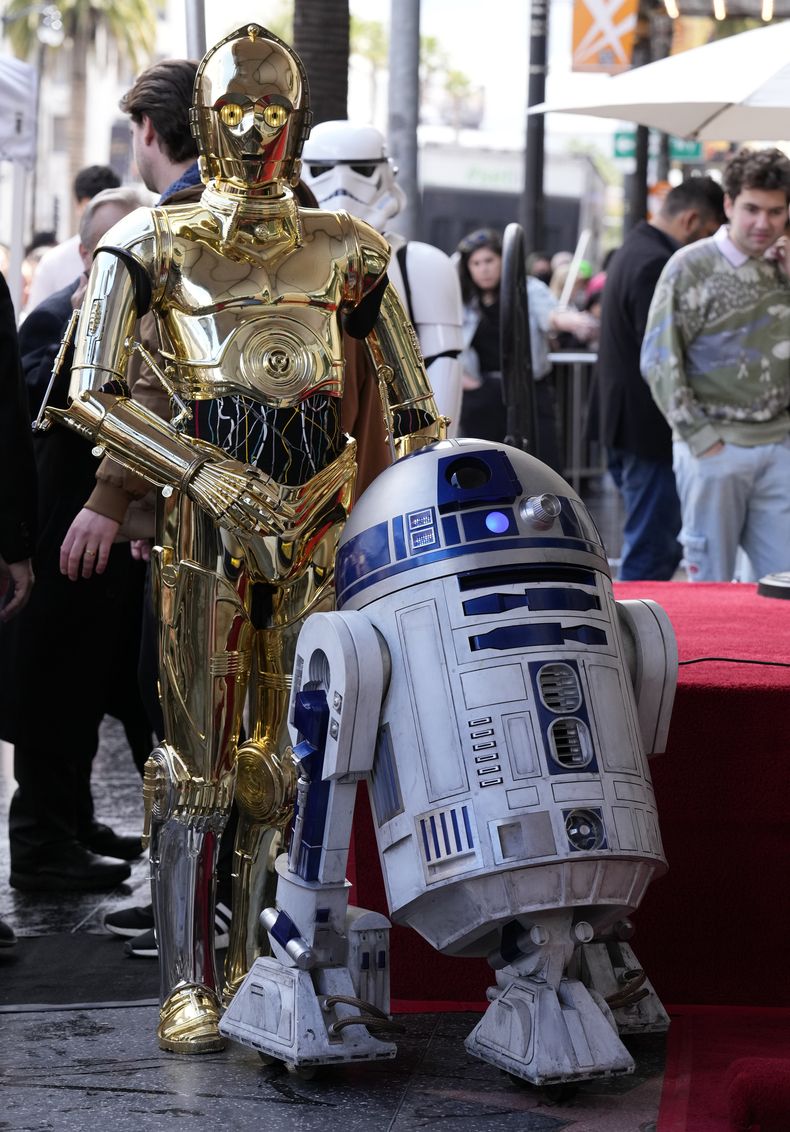 Los personajes de las películas de Star Wars C-3PO, izquierda, y R2-D2, en una ceremonia en honor a la fallecida actriz Carrie Fisher quien recibió una estrella póstuma en el Paseo de la Fama de Hollywood en Los Angeles el jueves 4 de mayo de 2023. La fecha se conoce también como Día de Star Wars, en homenaje a las películas de Star Wars en las que Fisher interpretó a la Princesa Leia. (Foto AP/Chris Pizzello)