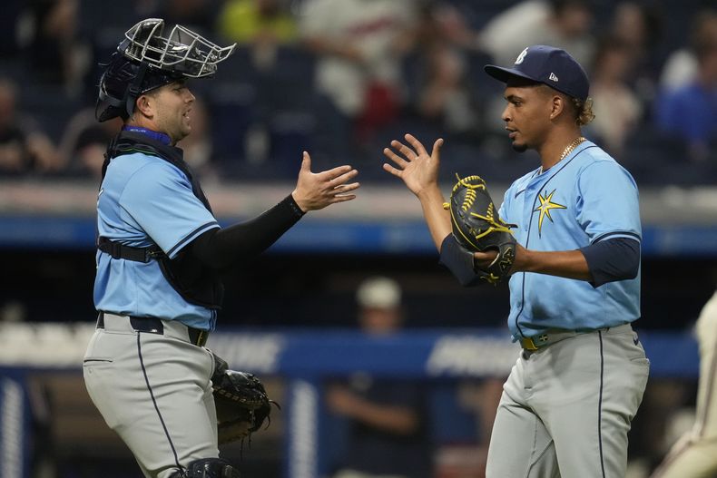 Logan Driscoll, izquierda, receptor de los Rays de Tampa Bay, celebracon el relevista Edwin Uceta, derecha, después de derrotar a los Guardianes de Cleveland en el juego de béisbol el viernes 13 de septiembre de 2024, en Cleveland. (AP Foto/Sue Ogrocki)