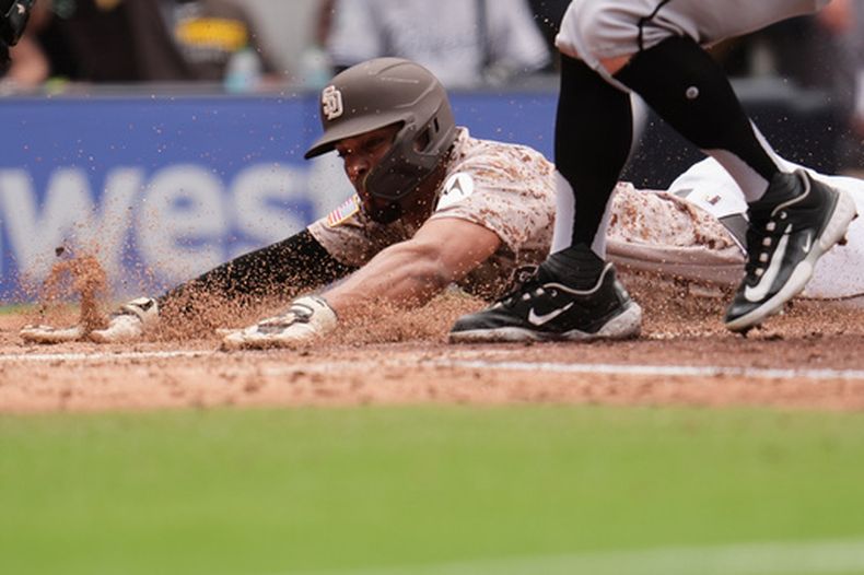 Xander Bogaerts, de los Padres de San Diego, se desliza para anotar desde la tercera base tras durante la cuarta entrada de un partido de béisbol contra los Medias Blancas de Chicago, el domingo 3 de mayo de 2026, en San Diego. (AP Foto/Gregory Bull)