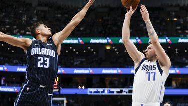Luka Doncic (77), de los Mavericks de Dallas, dispara sobre el intento de tapa de Tristan da Silva (23), del Magic de Orlando, durante la primera mitad del juego de baloncesto de la NBA, el domingo 3 de noviembre de 2024, en Dallas. (AP Foto/Gareth Patterson)