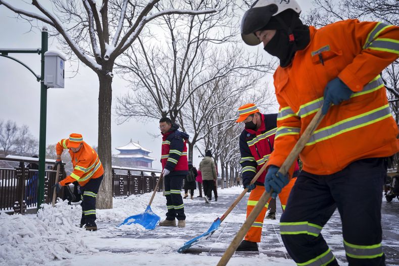 Trabajadores municipales despejan la nieve en una calle cerca de la Ciudad Prohibida tras una nevada en Beijing, el lunes 11 de diciembre de 2023. La nieve caída en buena parte del norte de China provocó cortes de carretera, clases suspendidas y cancelaciones de trenes el lunes. (AP Foto/Andy Wong)