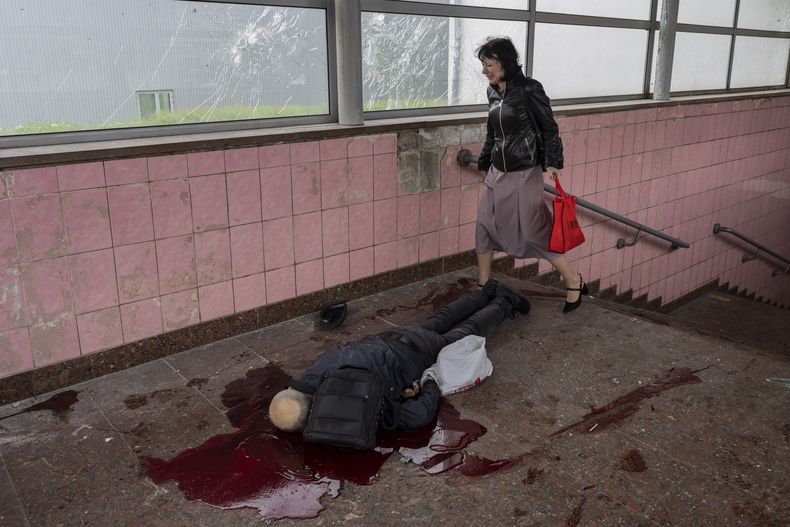 Elena camina hacia el cuerpo de su esposo Alexey, quien murió durante un ataque en Járkiv, Ucrania, el jueves 26 de mayo de 2022. (AP Foto/Bernat Armangue)