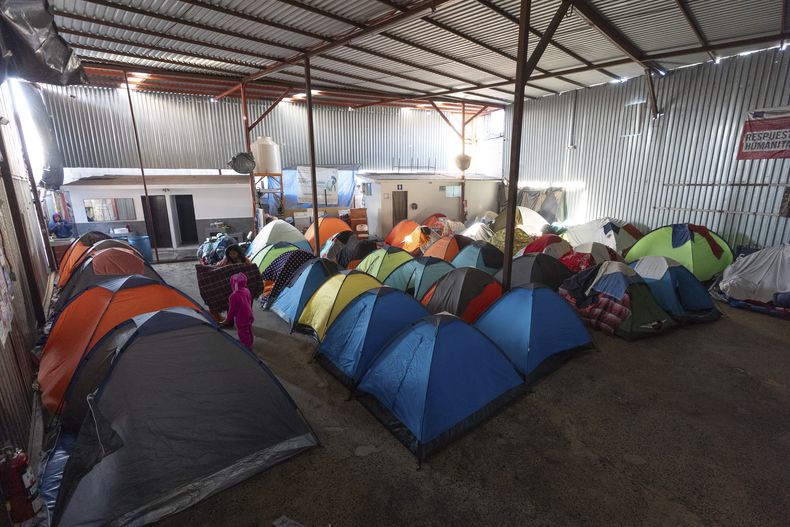 Margelis Rodríguez, de Venezuela, envuelve en una toalla a su hija de 6 años, Mackeliys, en la tienda donde se aloja la familia en un refugio migrante en Tijuana, México, el sábado 1 de febrero de 2025. (AP Foto/Gregory Bull)