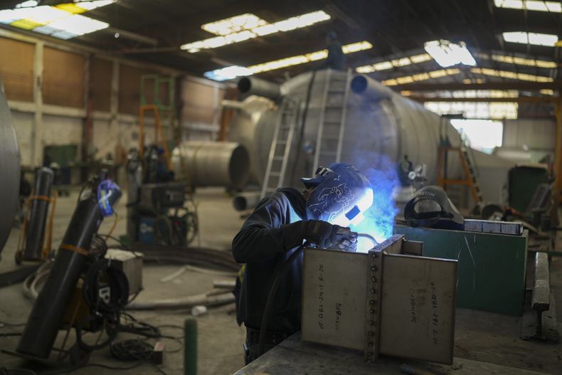 Un trabajador soldando en una fábrica de cilindros de acero en Ciudad de México, el martes 11 de febrero de 2025. (AP Foto/Eduardo Verdugo)