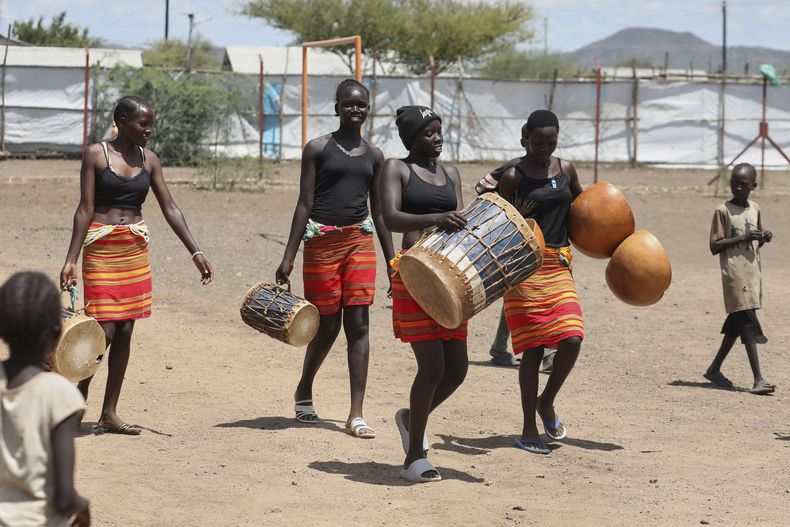Jóvenes bailarinas del grupo de Bailarinas Acholi se reúnen para ensayar su danza tradicional en el campamento de refugiados Kalobeyei, el lunes 2 de junio de 2025, en Turkana, Kenia. (AP Foto/Andrew Kasuku)