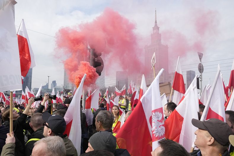 Agricultores polacos con banderas nacionales y letreros protestan contra las políticas agrícolas de la Unión Europea y contra las importaciones de alimentos de Ucrania, en Varsovia, Polonia, el martes 27 de febrero de 2024. (AP Foto/Czarek Sokolowski)