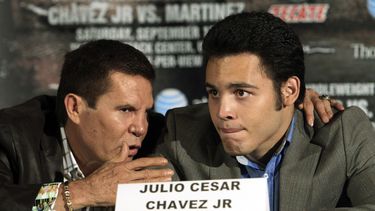ARCHIVO - Julio César Chávez Jr. (derecha), platica con su padre, el legendario boxeador Julio César Chávez (izquierda), durante una conferencia de prensa para promover su próxima pelea en Los Ángeles, el 10 de julio de 2012. (AP Foto/Reed Saxon, Archivo)