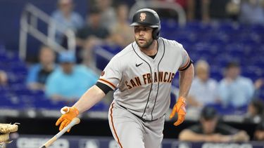 Darin Ruf, de los Gigantes de San Francisco, arroja el bate después de que le concedieran base por bolas en la primera entrada del partido contra los Marlins de Miami, en Miami, el miércoles 19 de abril de 2023. (AP Foto/Lynne Sladky)