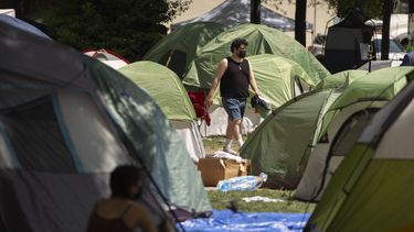 ARCHIVO - Una persona camina por un campamento establecido por estudiantes que protestaban contra la guerra entre Israel y Hamás en la Universidad George Washington, el martes 30 de abril de 2024, en Washington. (AP Foto/Mark Schiefelbein, archivo)