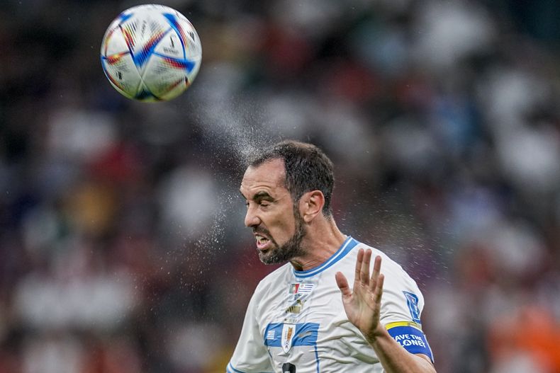 ARCHIVO - Foto del 28 de noviembre del 2022, el uruguayo Diego Godín con un cabezazo al balón durante el encuentro ante Portugal en la Copa Mundial de Qatar. El lunes 31 de julio del 2023, Godín anuncia su retiro tras 20 años de carrera. (AP Foto/Abbie Parr, Archivo)