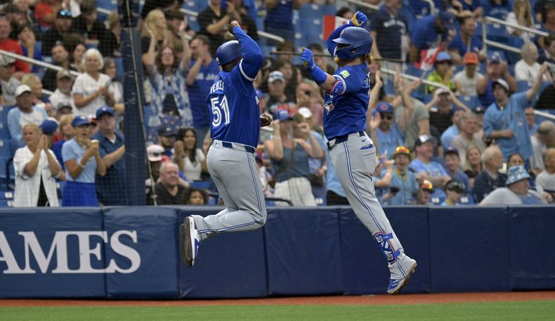 Justin Turner, derecha, de los Azulejos de Toronto, celebra con el coach de tercera Carlos Febles después de un cuadrangular solitario frente a Tyler Alexander, de los Rays de Tampa Bay, durante la quinta entrada del juego de béisbol, el domingo 31 de marzo de 2024, en San Petersburgo, Florida. (AP Foto/Steve Nesius)