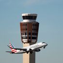 Un avión American Eagle de American Airlines pasa por la torre de control de tráfico aéreo en el Aeropuerto Internacional Phoenix Sky Harbor, el sábado 8 de noviembre de 2025, en Phoenix. (AP Foto/Ross D. Franklin)