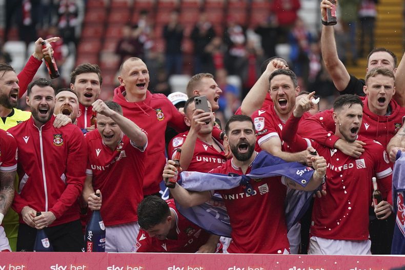 Jugadores del Wrexham celebran en el campo el ascenso del equipo a la League One al fial del encuentro ante Forest Green el sábado 13 de abril del 2024. (Jacob King/PA via AP)